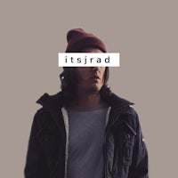 a man wearing a beanie and a jacket with the word iraad on it